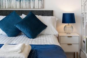 a bedroom with a bed with blue pillows at Amazing Studio in Central London - 5 in London