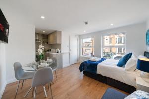 a bedroom with a bed and a table and a kitchen at Amazing Studio in Central London - 5 in London
