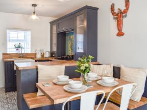 a kitchen and dining room with a wooden table at White Horses - Uk42776 in Newborough
