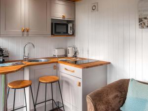 una piccola cucina con lavello e microonde di School Lodge a Burwarton