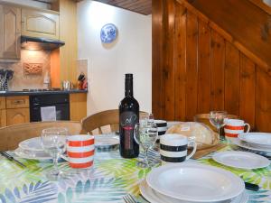 a table with a bottle of wine and plates on it at Llofft Yr Yd - 16984 in Brynsiencyn +8 photos
