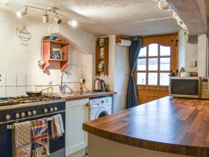 een keuken met een fornuis en een aanrechtblad bij Hoopers Farmhouse - Uk36307 in Tilshead