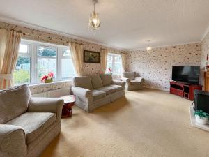 a living room with two couches and a television at Tredegar in Newton Stewart