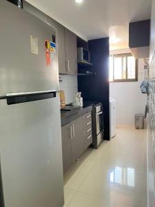 a kitchen with a stainless steel refrigerator in a room at Flat Costa Nova VIP - em Ponta Verde - Apartamento 202 - 1 Quarto - Proximo a Praia in Maceió +8 photos