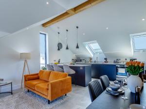 a living room with an orange couch and a kitchen at Sea Skapya - Uk50178 in Helston +23 photos