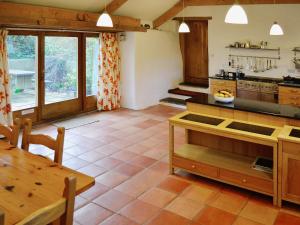 a large kitchen with a wooden table and a table sidx sidx sidx at Last Barn in Saint Twynnells