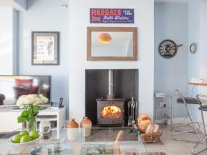 a living room with a fireplace and a stove at Seaspray, Coastguard Cottages in Dawlish