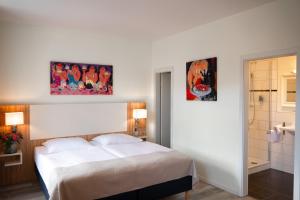 a bedroom with a bed and two pictures on the wall at Hotel Trierer Hof in Koblenz +33 photos