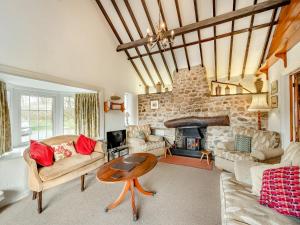 a living room filled with furniture and a stone fireplace at Cwm Eithin Cerbid - Cottage in Llanhowell +31 photos