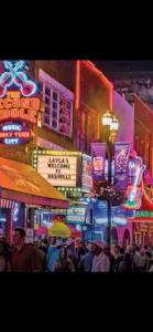 a crowd of people walking down a city street at night at Cottage by the cabin in Springfield