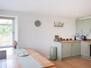 a kitchen with white cabinets and a table in it at High Wardneuk - Uk47041 in Symington