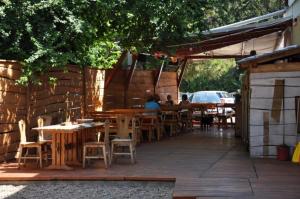 a patio with tables and chairs and a building at Hullam Hostel in Révfülöp