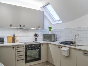 a kitchen with white cabinets and a sink at Roof Tops in York