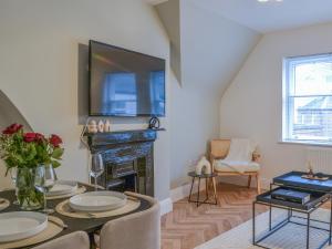 a living room with a table with a television and a fireplace at Roof Tops in York