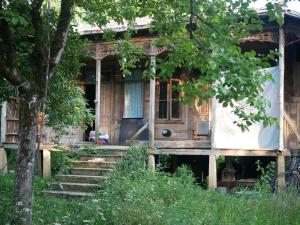 an old house with stairs leading to the front door at Mettavasi in Kutaisi