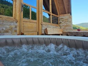 a hot tub in front of a building at Vikendica GORSKI VUK Jelovica in Berane +62 photos
