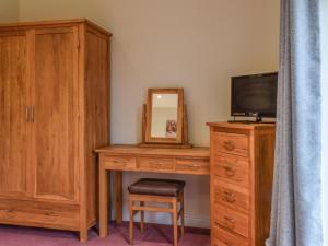 1 dormitorio con escritorio, TV y tocador en Sandpiper, en Carnforth 8 fotos más