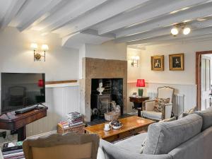a living room with a couch and a fireplace at Wattle Cottage in Belper