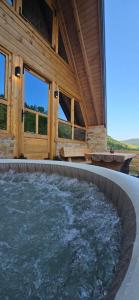 a hot tub in a wooden house with a building at Vikendica GORSKI VUK Jelovica in Berane