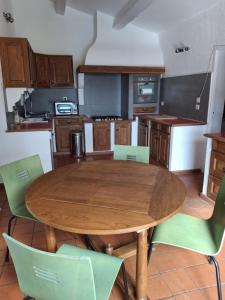 eine Küche mit einem Holztisch und grünen Stühlen in der Unterkunft Maison de vacances à La Ciotat Ceyreste in Ceyreste