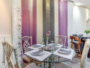 a dining room with a glass table and chairs at Ty Menyn - Uk45716 in Brynteg