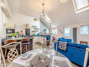 a living room and kitchen with a blue couch at Ty Menyn - Uk45716 in Brynteg