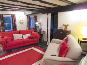 a living room with a red couch and a red rug at Garden Cottage in Threlkeld