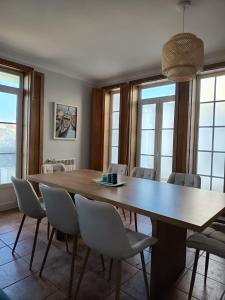 a dining room with a large wooden table and chairs at Villa Nenúfares in Torreira +38 photos