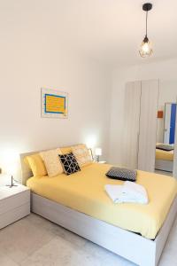 a bedroom with a large bed with yellow sheets at Casa cobalto vicinissima al centro by Turin House Collection in Turin