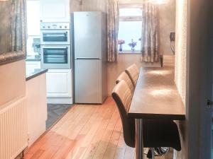 a kitchen with a wooden table and a refrigerator at Moor View in Newton Abbot