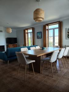 a living room with a large wooden table and chairs at Villa Nenúfares in Torreira