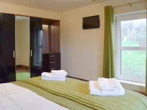 una camera da letto con un letto con asciugamani sopra di Bont Cottage a Kidwelly