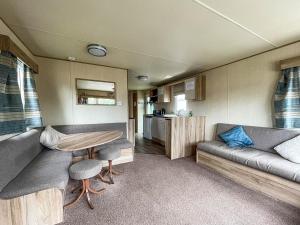 a living room with a couch and a table in a trailer at Au Bords Du Lac - Uk49028 in Tattershall