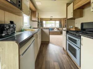 a kitchen with a stove and a counter top at Au Bords Du Lac - Uk49028 in Tattershall