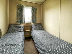 two beds in a small room with a window at Au Bords Du Lac - Uk49028 in Tattershall