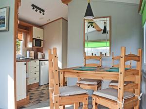 una sala da pranzo con tavolo e sedie e una cucina di The Lodge - Uk48785 a Llangefni