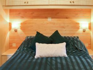 un letto con cuscini bianchi e neri sopra di The Lodge - Uk48785 a Llangefni Altre 3 foto