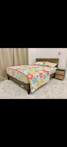 a bed with a floral comforter in a bedroom at Tile House Apartments Gunjur Kolkoch in Gunjur