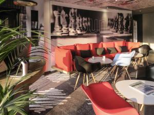 un restaurante con mesas y sillas rojas y negras en ibis Soissons, en Soissons