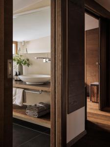 a bathroom with a white sink and a tub at Hotel Sandhof in Lech am Arlberg +148 photos