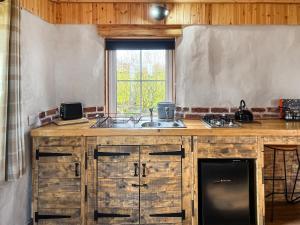 a kitchen with a counter and a sink and a window at Willow Bale Cabin - Uk49074 in Ballindalloch