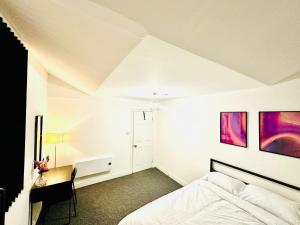 Un dormitorio con una cama y cuadros en la pared. en Albert Inn, en Mánchester