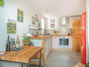 a kitchen with a wooden table and a red refrigerator at Y Gwairdy in Carmel
