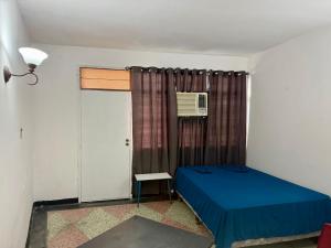 a bedroom with a blue bed and a window at Casa Mateo in Maracaibo