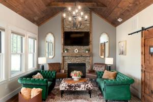 a living room with green furniture and a fireplace at Boutique Luxury Stay Near JMU with 2 King Suites & Fireplaces in Grottoes