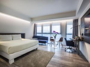a bedroom with a bed and a table and chairs at Novotel Roma Eur in Rome +63 photos