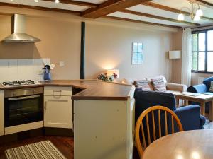 a kitchen and living room with a table and a couch at Jasmine Cottage - E1493 in Scalby