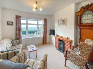 a living room with a fireplace and a clock at Bryn View Villa - Uk48825 in Mochdre