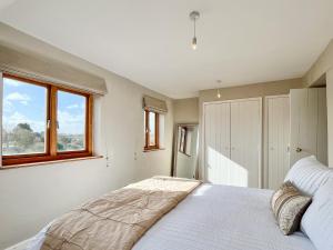 a bedroom with a white bed and a window at Drovers Cottage in Tetbury +15 photos