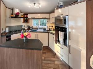 a kitchen with white cabinets and a counter with flowers at 5 Pine Rise in Poole +11 photos
